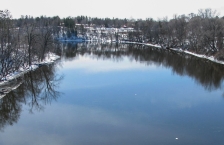 Wide river in winter with snow on banks.