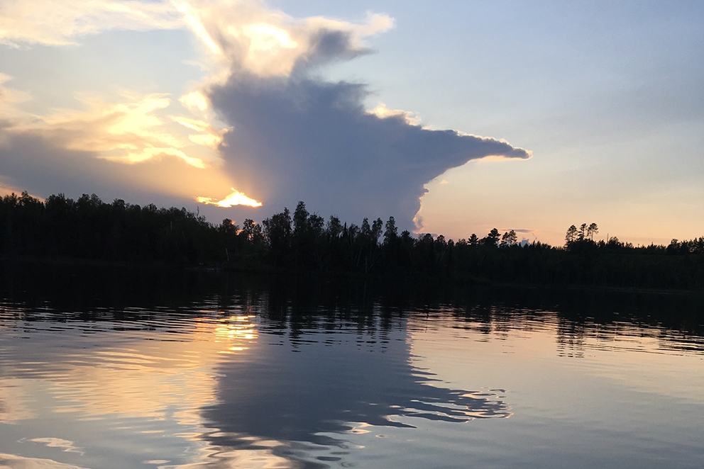 A view of Armstrong lake at sunset. The clouds in the sky and reflected on the water make the shape of Minnesota.