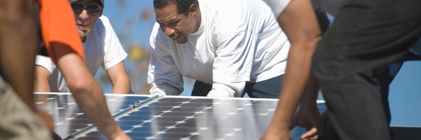 Men install a solar panel.