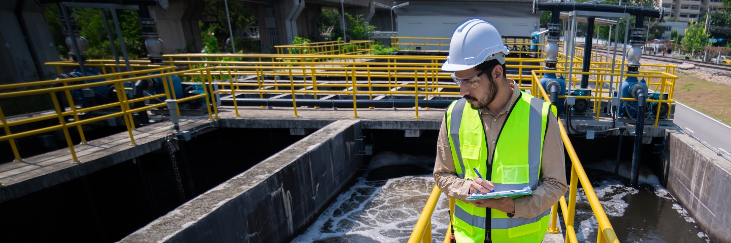 Worker at a wastewater treatment plant holding a clipboard.