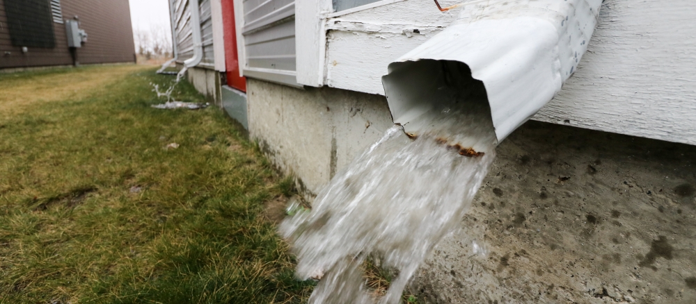 rain coming out of rain gutter on house