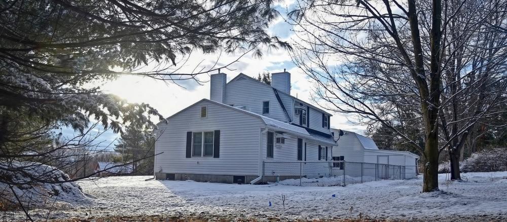 White rural house framed by trees