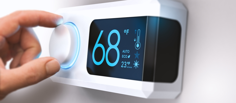 Hand adjusting a digital thermostat