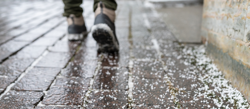 Winter boots on a sidewalk covered with salt.