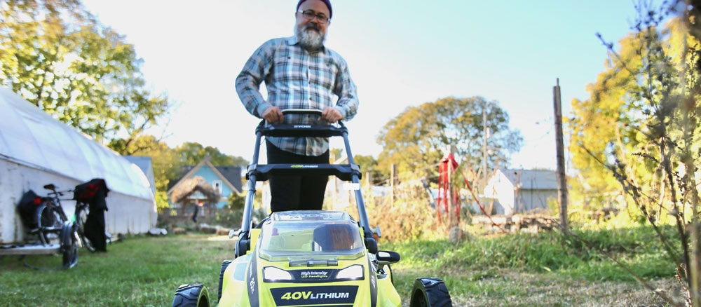 Person pushing a battery-powered lawn mower. 