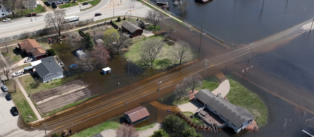 Aerial view of a river flooding a town.