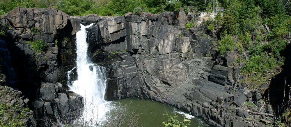 A waterfall cascades down a rock face.