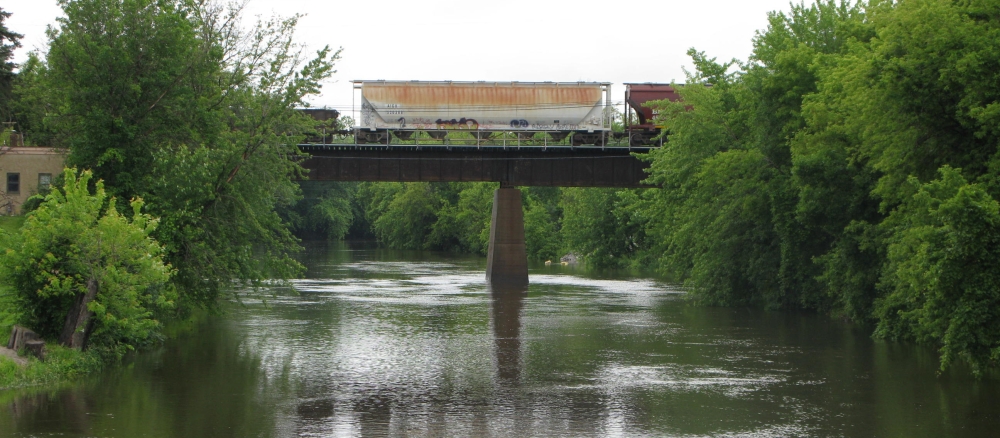 Railroad cars on bridge crossing a river.