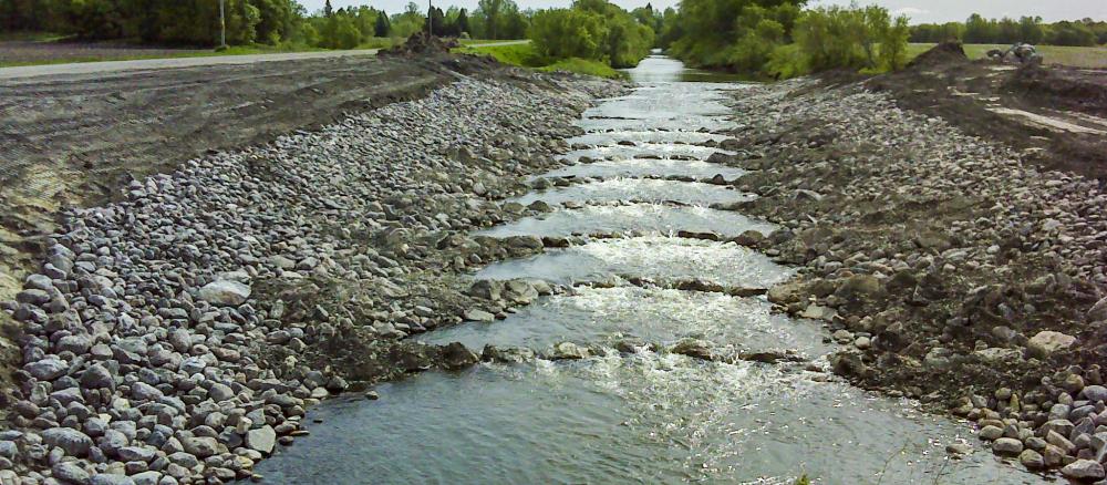 Stream with rock and gravel ridges crossing stream