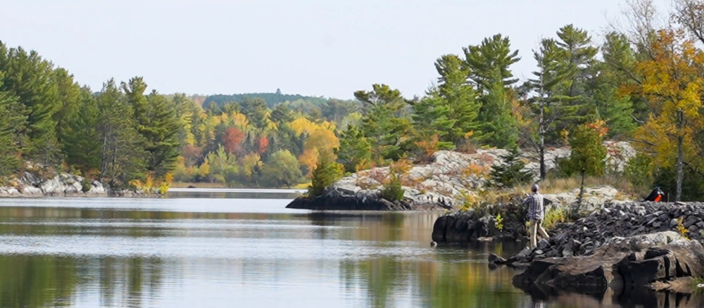 Person fishes from rocky shore of Thompson Reservoir