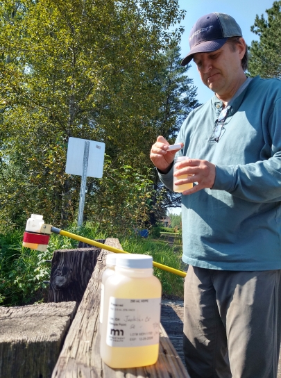 MPCA environmental specialist Kevin Stroom takes water samples at Jenkins Creek, west of Cotton, Minnesota