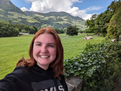 Portrait of Francesca Cregoin front of an open green field with mountains in the distance