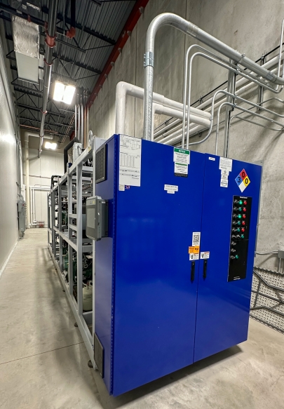A bright blue metal box with various sizes of metal tubes coming out of it. 