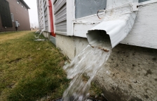 rain coming out of rain gutter on house