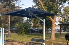 A blue shade canopy protects a bench at Ainsworth Park in St. Louis Park, Minnesota.
