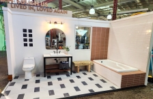 Reuse room exhibit at the Minnesota State Fair showing a bathroom constructed with a rescued toilet, sink, and vanity, a bench made with reclaimed wood, and new flooring that was destined for a landfill.