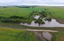 Aerial view of flooding in farm fields with a stormwater berm in the foreground.