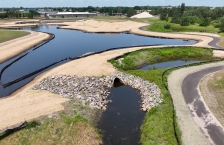 Aerial view of small stormwater ponds surrounded by erosion control blankets and a walking path on the right side.