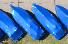 Overhead view of four boats wrapped in blue boat wrap, parked diagonally..