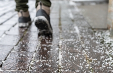 Winter boots on a sidewalk covered with salt.