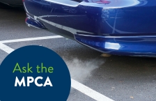 Close up of exhaust from tailpipe of idling car in a parking lot.