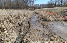 Mud from road construction flowing over sediment filter socks into a wetland.