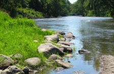 Close up of a small stream joining a larger river.