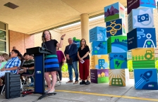 Commissioner Katrina Kessler speaking at a podium, Governor Tim Walz and Lt. Governor Peggy Flanagan stand in the background.