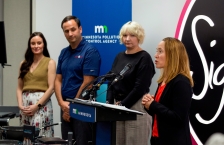 MPCA commissioner Katrina Kessler speaking into a microphone as three other people look on. 