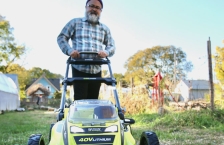 Person pushing a battery-powered lawn mower. 
