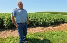 A man standing in front of a soybean field.
