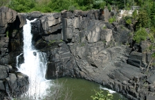 A waterfall cascades down a rock face.