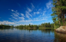 Blue sky with white clouds over wilderness lake.