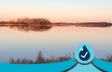 A very calm, still lake at sunset in autumn.