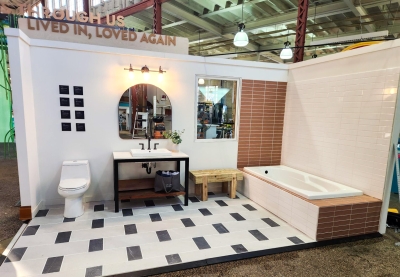 Reuse room exhibit at the Minnesota State Fair showing a bathroom constructed with a rescued toilet, sink, and vanity, a bench made with reclaimed wood, and new flooring that was destined for a landfill.
