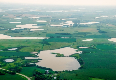 Aerial view of a green landscape dotted with small lakes.