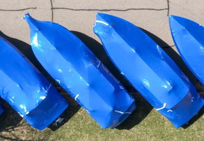 Overhead view of four boats wrapped in blue boat wrap, parked diagonally..