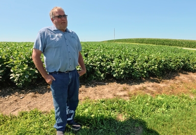 A man standing in front of a soybean field.
