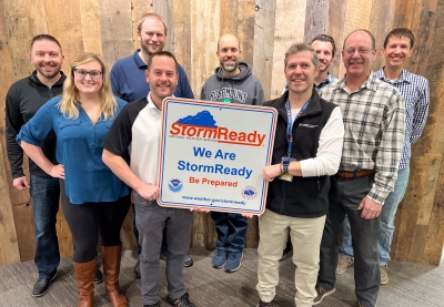 Group of people holding a sign that reads Storm Ready, we are storm ready, be prepared.