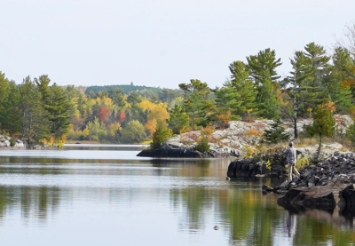 Person fishes from rocky shore of Thompson Reservoir