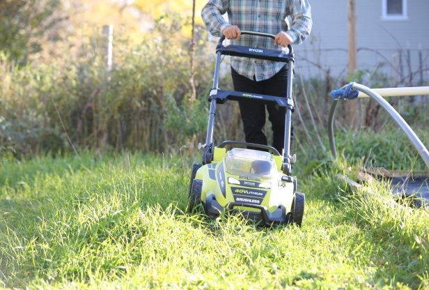 Person cutting grass with an electric lawnmower