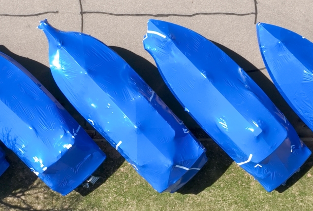Overhead view of four boats wrapped in blue boat wrap, parked diagonally..