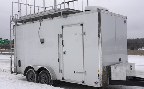 the mobile air monitoring station looks like a large trailer with wheels and air monitoring equipment on the roof.
