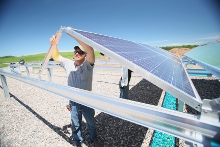 Man installing solar panel at the Washington County Landfill