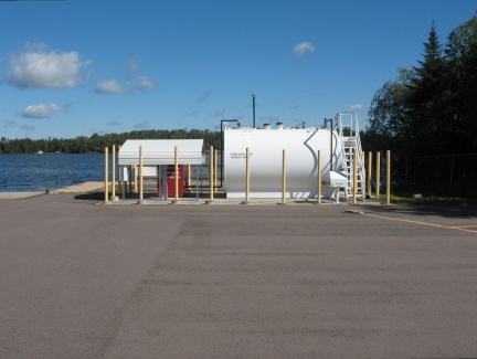 White aboveground storage tank next to a lake.