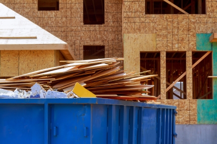 Dumpster with wood scraps and construction debris.