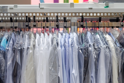 Clean clothes on hangers at dry cleaners.