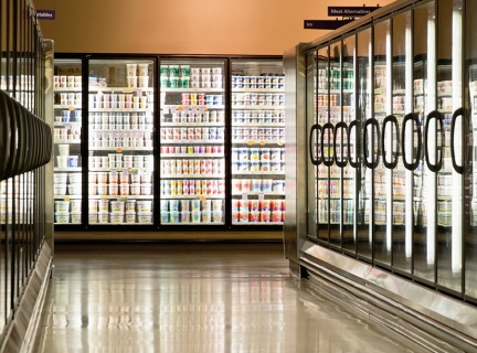 An aisle of refrigerators in a retail setting.