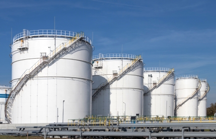 Large white oil storage tanks and pipes.