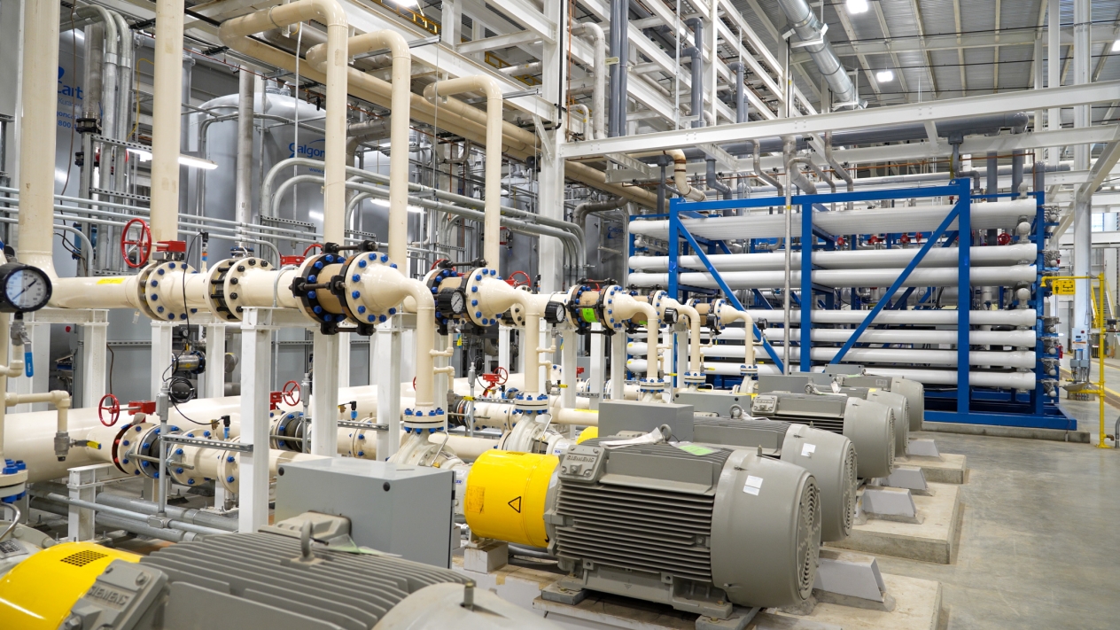 A series of white pipes inside a water treatment facility.